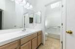 This bathroom features a bright and airy design with a large vanity and ample counter space.