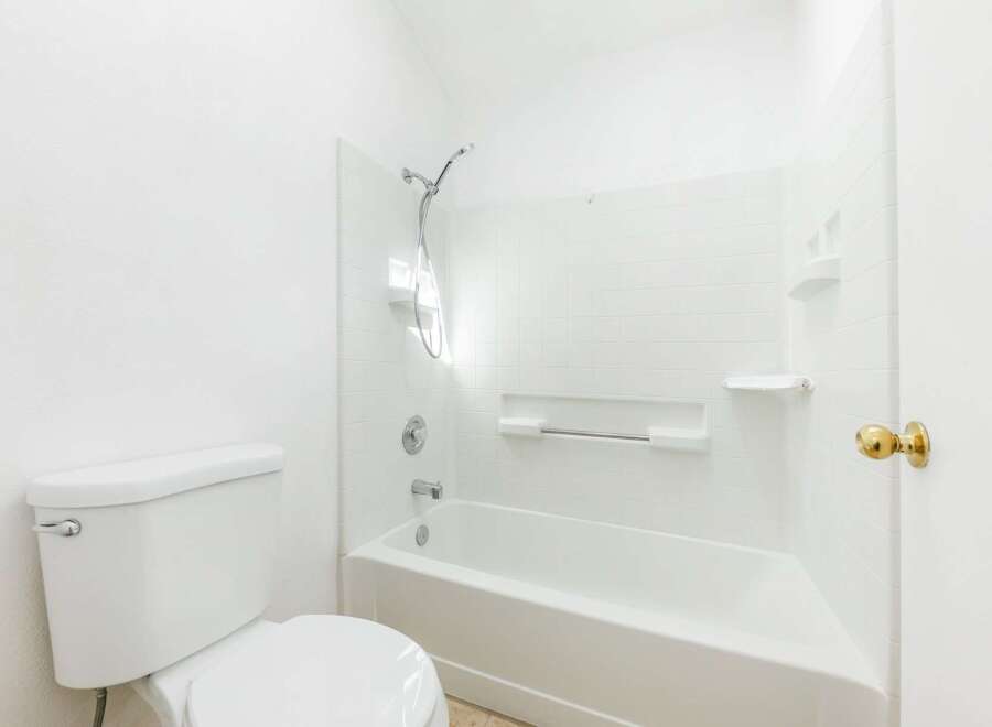 Step into this bright and clean bathroom, featuring a pristine white bathtub and shower combo.