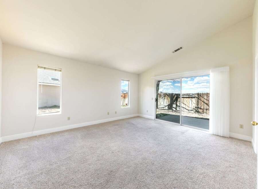 Step into this bright and airy living space, featuring a vaulted ceiling and ample natural light.