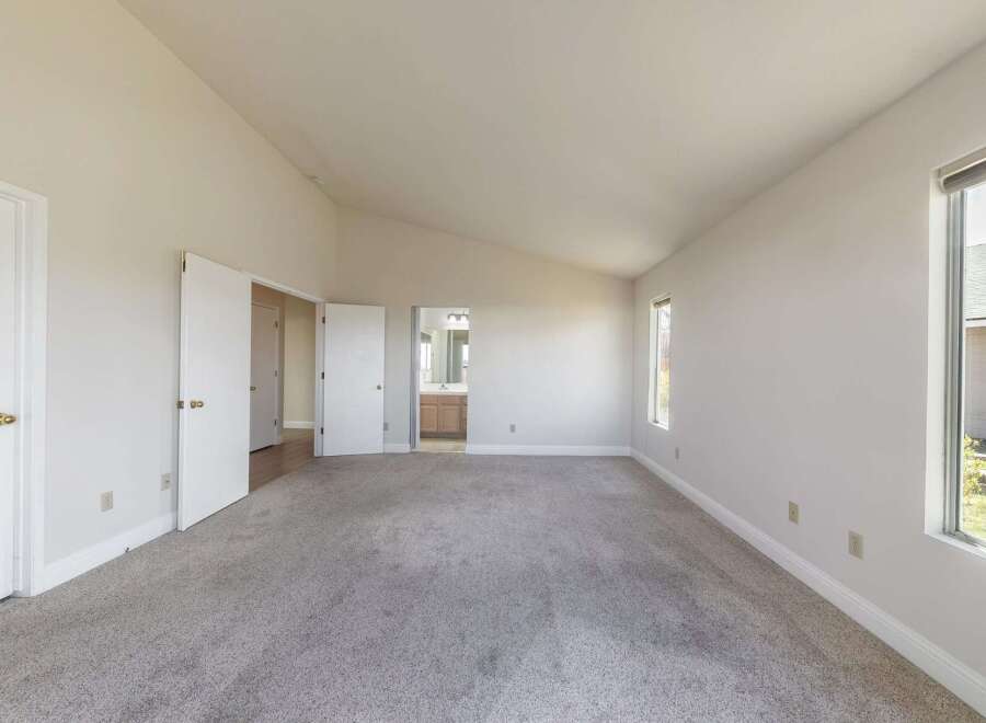 Step into this spacious bedroom, featuring a vaulted ceiling that amplifies the sense of openness.