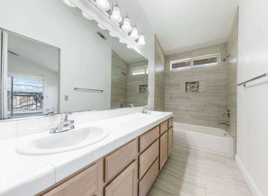 Step into this beautifully designed bathroom featuring a double vanity with ample counter space and storage.