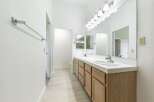 This bright and airy bathroom features a dual-sink vanity with ample storage.