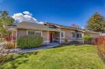 This charming home boasts a welcoming red front door and a well-maintained exterior.