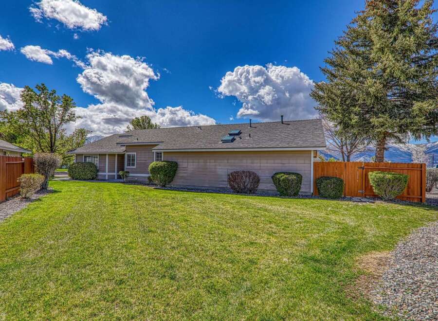 This charming property boasts a well-maintained exterior with lush green lawns and mature landscaping.