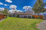 This charming property boasts a well-maintained exterior with lush green lawns and mature landscaping.