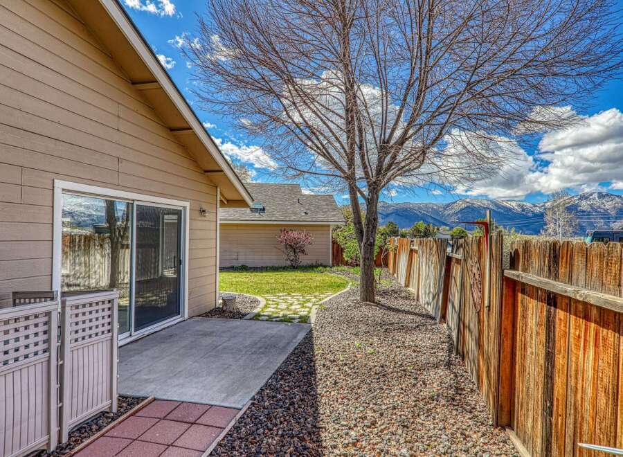 Enjoy the beauty of this property's outdoor space, featuring a charming patio and a well-maintained wooden fence.