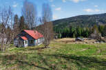 Nestled in a serene landscape, this property boasts a charming house with a vibrant red roof.