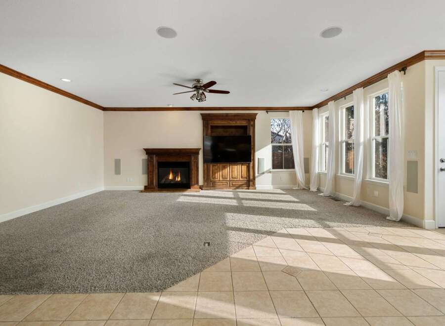 Step into luxury with this stunning living room, featuring a cozy fireplace and a built-in entertainment center.