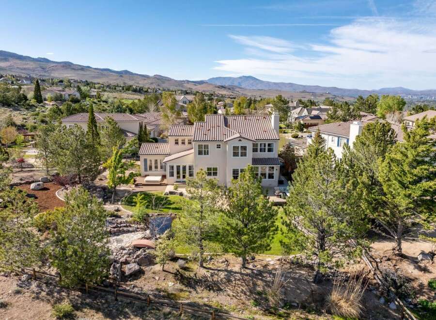 This stunning property boasts a luxurious design with a beautiful tile roof and expansive windows.