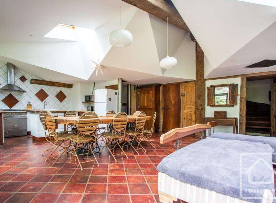 Discover the charm of this unique property, featuring a spacious open-plan living area with a rustic dining table perfect for gatherings.