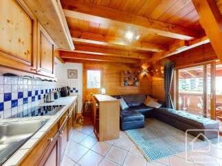 This charming property boasts a cozy kitchen with wooden cabinetry and a modern cooktop.