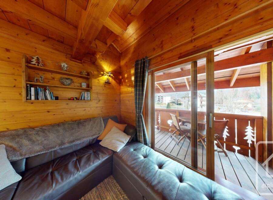 Experience the warmth of this cozy cabin with its inviting wooden interior and stunning balcony views.