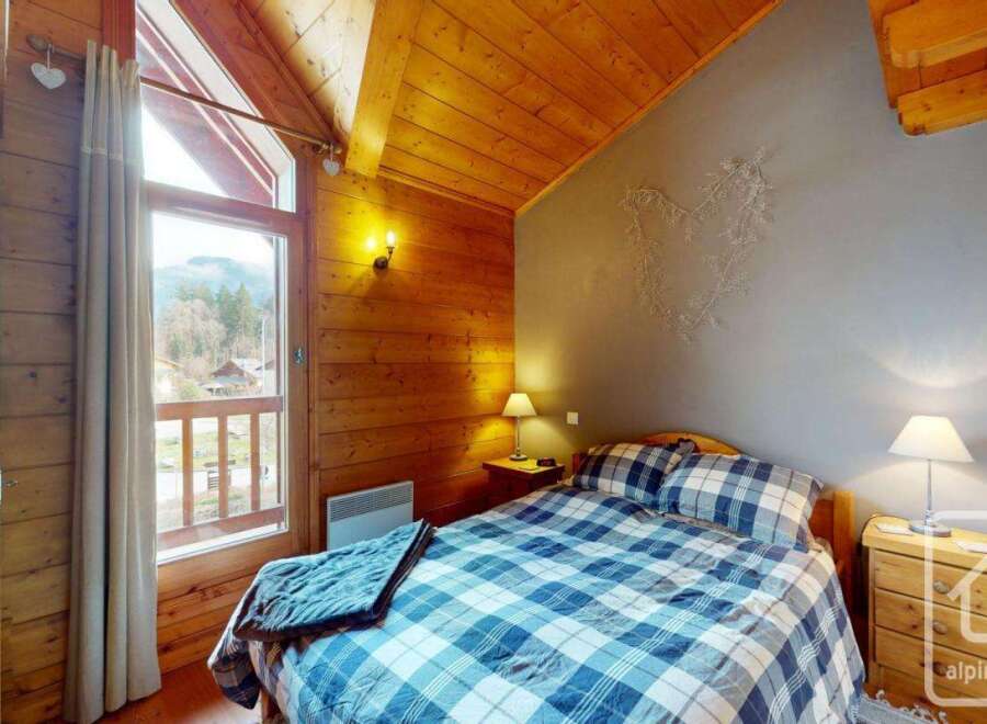 Discover the charm of this cozy bedroom, featuring a rustic wooden interior and a stunning view.