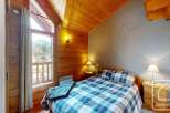 Discover the charm of this cozy bedroom, featuring a rustic wooden interior and a stunning view.