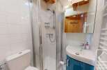 Discover this charming bathroom featuring a modern shower and a stylish sink.