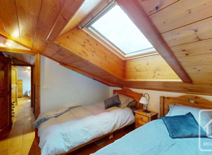 Discover the charm of this cozy bedroom featuring a unique sloped ceiling and a skylight that floods the space with natural light.