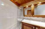 Discover the charm of this beautifully designed bathroom, featuring a stylish wooden vanity and a modern shower enclosure.