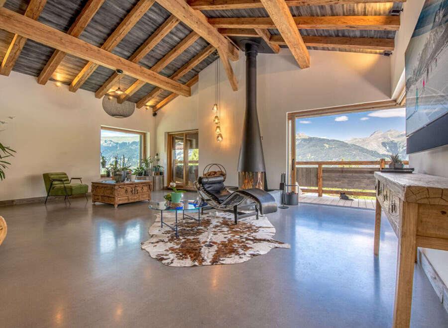Experience luxury living in this stunning property, featuring a spacious living area with a modern fireplace and breathtaking mountain views.
