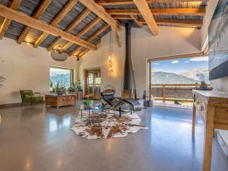 Experience luxury living in this stunning property, featuring a spacious living area with a modern fireplace and breathtaking mountain views.