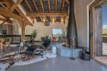Experience luxury living in this stunning property featuring a modern fireplace and exposed wooden beams.