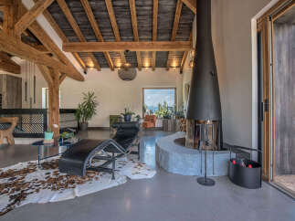 Experience luxury living in this stunning property featuring a modern fireplace and exposed wooden beams.