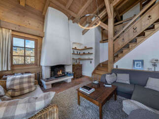 Experience the warmth of this stunning chalet, featuring a cozy fireplace and exposed wooden beams.