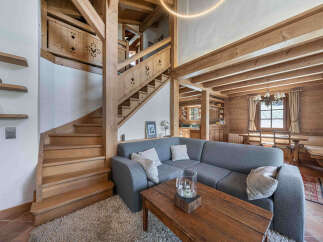 Step into rustic elegance with this stunning property featuring a beautifully crafted wooden staircase and exposed beams.