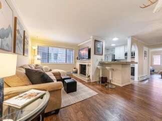 Discover this stunning property featuring a cozy living room with a fireplace and a modern kitchen.