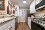 This charming kitchen boasts a stylish design with its white cabinetry and granite countertops.