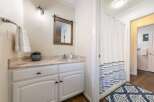 This charming bathroom features a stylish vanity with ample storage, a beautiful mirror, and a modern light fixture.