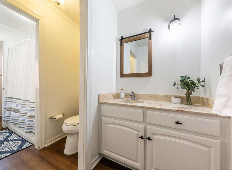 This charming bathroom features a stylish vanity with ample storage and a beautiful countertop.