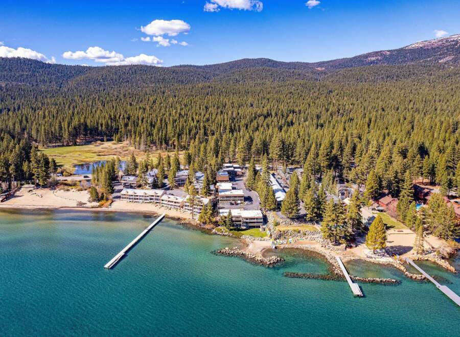 Discover a stunning lakeside property nestled amidst towering pine trees.