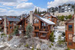 Discover luxury living in this stunning mountain home! This property boasts a beautiful exterior with a stone chimney, wooden balconies, and a hot tub.