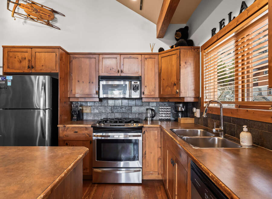 This stunning kitchen boasts rustic charm with its wooden cabinetry and stainless steel appliances.