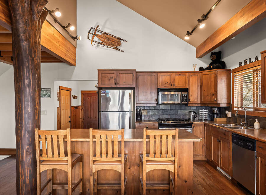 This stunning kitchen showcases rustic charm with its wooden cabinetry and exposed beams.