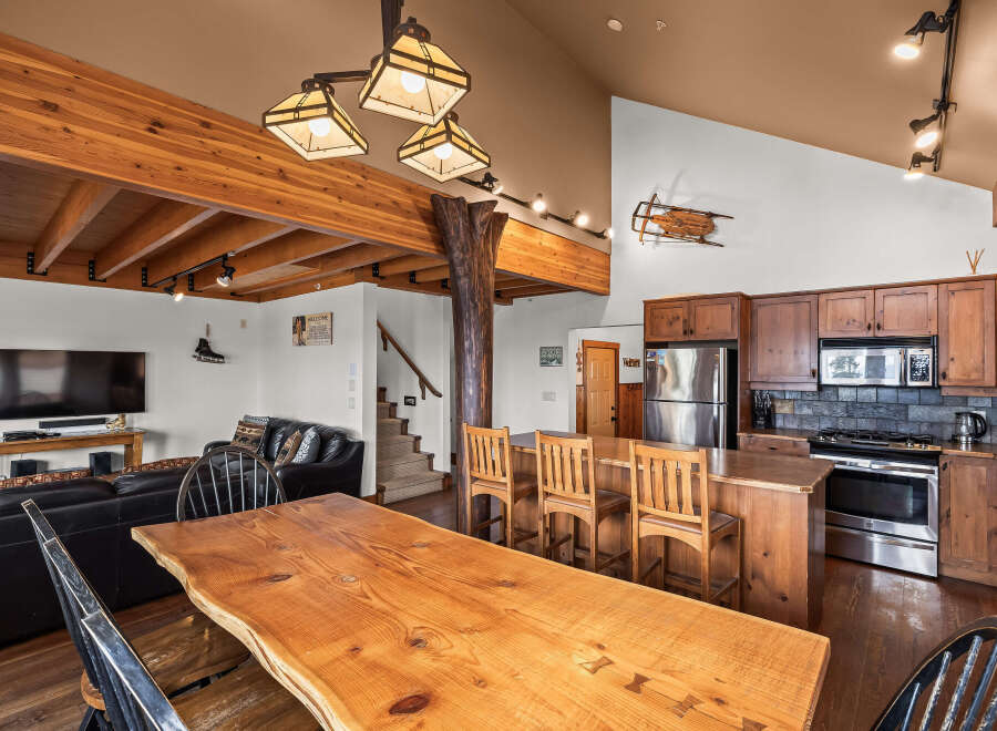 This stunning property boasts a rustic charm with its exposed wooden beams and a live-edge dining table, creating a warm and inviting atmosphere.
