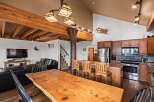 This stunning property boasts a rustic charm with its exposed wooden beams and a live-edge dining table, creating a warm and inviting atmosphere.