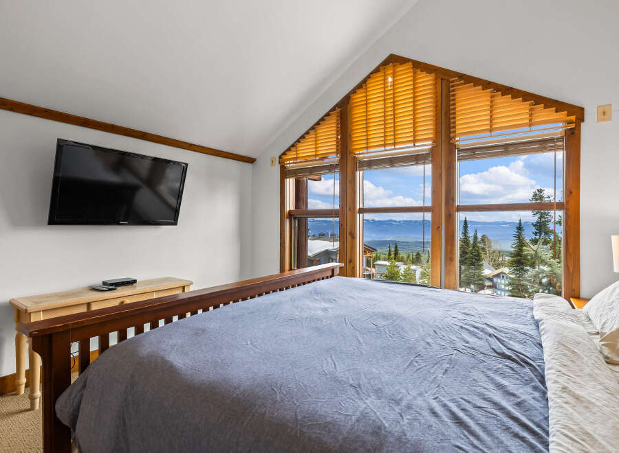 Experience breathtaking mountain views from this stunning bedroom.