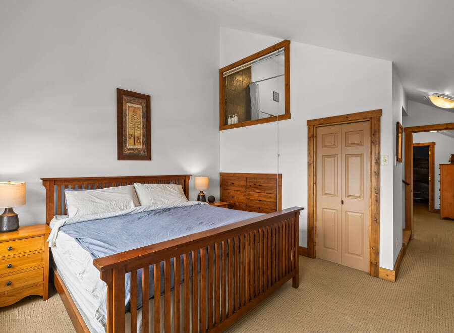 This inviting bedroom features a cozy king-sized bed with a stylish wooden frame, perfect for a relaxing retreat.
