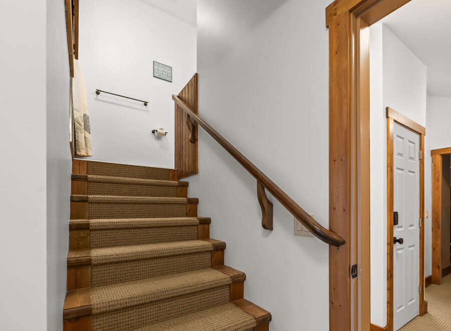 This stunning property features a beautifully designed staircase with wooden accents and a cozy carpet runner.