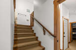 This stunning property features a beautifully designed staircase with wooden accents and a cozy carpet runner.