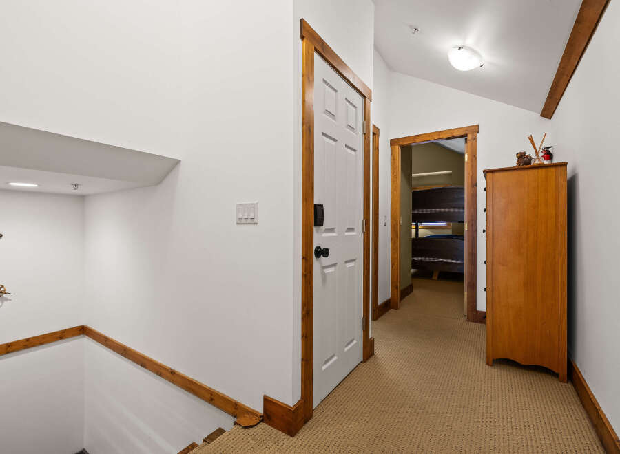 Step into this inviting hallway, featuring a warm, neutral carpet and crisp white walls.