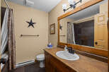 This charming bathroom features a rustic design with a wooden vanity and a stylish sink.