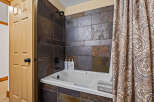 Step into a beautifully designed bathroom featuring a stylish tile shower and a relaxing bathtub.