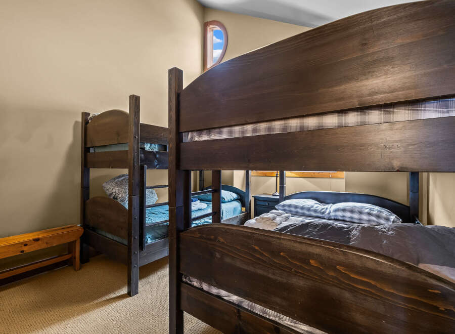 This cozy bedroom features two sets of bunk beds, perfect for accommodating multiple guests or family members.