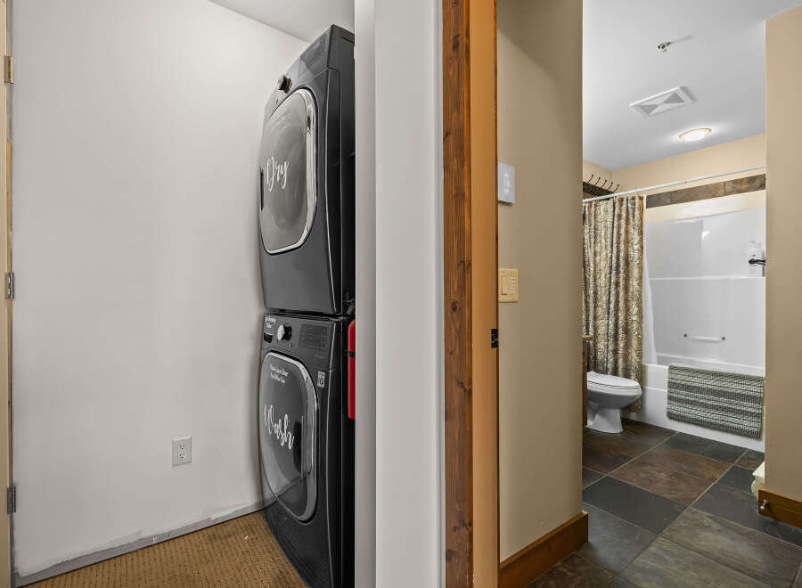 This property features a convenient laundry area with a stacked washer and dryer, perfect for modern living.