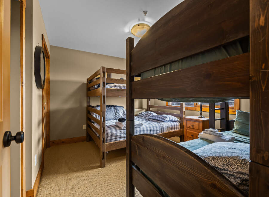 This cozy bedroom features two sets of bunk beds, perfect for accommodating multiple guests or family members.