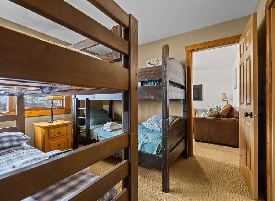 This cozy bedroom features two sets of bunk beds, perfect for accommodating a large family or group of friends.
