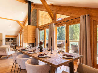Experience luxury living in this stunning property featuring a spacious dining area with a rustic wooden table, perfect for hosting gatherings.