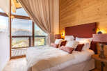 Experience luxury living in this stunning bedroom with breathtaking mountain views.